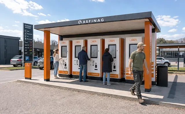 ASFINAG-Mautautomaten an einer Raststation mit mehreren Personen bei der Bedienung. Bild steht für digitale Vignettenservices, einfache Mautabwicklung und kundenfreundliche Infrastruktur.